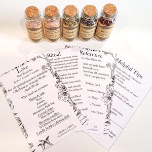 May include: A set of six small glass bottles with cork tops, each filled with different herbs, crystals, and salts. The bottles are labeled with the names of the ingredients and their uses, such as "Love", "Rose", "Lavender", "Linden", "Himalayan Pink Salt", and "Rose Quartz". The bottles are arranged on a white background with three cards that describe the ritual, reference, and helpful tips for using the ingredients.