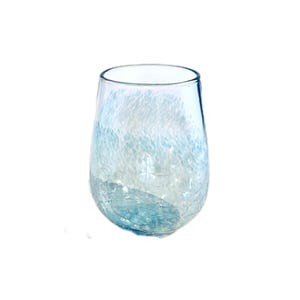 May include: A clear, stemless glass with a blue and white speckled pattern. The base of the glass has a cracked ice effect. The glass has a rounded, oval shape and is empty.