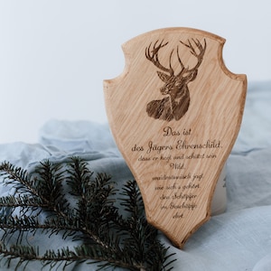Puede incluir: Una placa de madera con una silueta de ciervo y el texto "Das ist des Jägers Ehrenschild. dass er hegt und schützt sein Wild waidmännisch jagt wie sich's gehört, den Schöpfer im Geschöpfe ehrt."