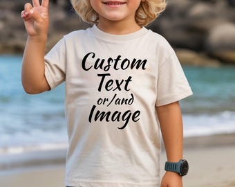 May include: A beige short-sleeved t-shirt featuring the black printed text Custom Text or/and Image centered on the front. The shirt has a crew neckline and a standard fit, providing a neutral base for personalized graphic designs or lettering.