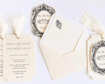 May include: Cream-colored wedding invitation suite featuring two rectangular cards with scalloped edges, a matching envelope with a small black floral motif, and two oval-shaped Save The Date cards with ornate black frames and swan illustrations.