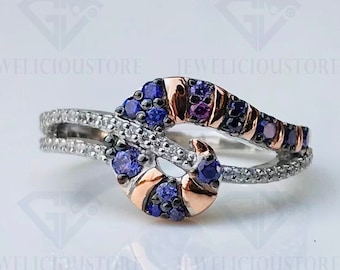 May include: A silver ring with a twisted design featuring a row of purple and pink gemstones. The ring is set with smaller clear gemstones.
