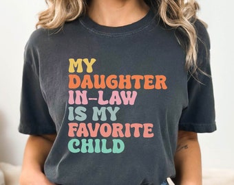 May include: A dark gray t-shirt with the text "My daughter-in-law is my favorite child" in rainbow colors.