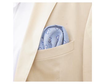 May include: A light beige blazer with a blue pocket square featuring a white paisley pattern.