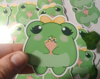 Adhesivo brillante de rana con ramo de flores de primavera