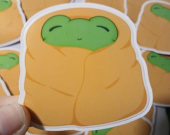 Pegatina brillante de rana con manta acogedora