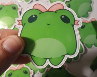 Pegatina brillante de rana con lazo rosa coqueta