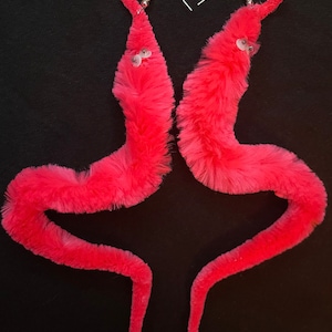 May include: A pair of pink fluffy worm earrings with silver hooks. The worms have googly eyes.