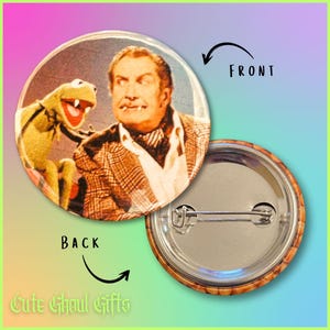 May include: A circular badge displaying a vintage image of a man and Kermit the Frog. The front of the badge shows the image, while the back reveals a pin. The text "Cute Ghoul Gifts" is visible. The badge is a collectible item.