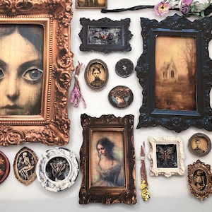 Op de afbeelding: Een galerijwand met diverse sierlijke lijsten in goud, zwart, wit en brons. De collectie bevat portretten, een landschap met een gebouw, bloemenkunst, skeletfiguren, insectenexemplaren en kleine bundels met gedroogde bloemen.
