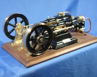 Peut inclure: Un petit modèle de machine à vapeur en noir et laiton sur une base en bois. Le moteur a deux cylindres et un volant d'inertie. Le moteur est monté sur une base en bois avec une plaque en laiton portant l'inscription "Davis".
