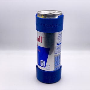 May include: A blue can holder with the text "gogoMakes.com" printed on it. The holder is around a silver can of Red Bull energy drink. The can is 16.9 fl oz and has 110 calories per can.