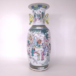 Puede incluir: Una taza de cerámica blanca con un asa negra y el texto "But First, Coffee" en un estilo manuscrito. La taza está sobre una superficie blanca. La taza mide aproximadamente 10 cm de alto.