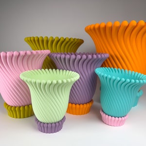 May include: A set of six colorful, decorative planters with a unique, swirling design. The planters are made of a smooth, textured material and come in a variety of sizes.