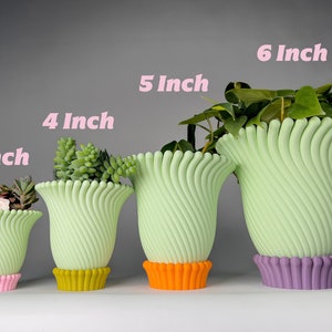 May include: Four green ceramic planters with different colored bases, ranging in size from 3 inches to 6 inches. The planters are all in the same style, with a wavy, ribbed design.