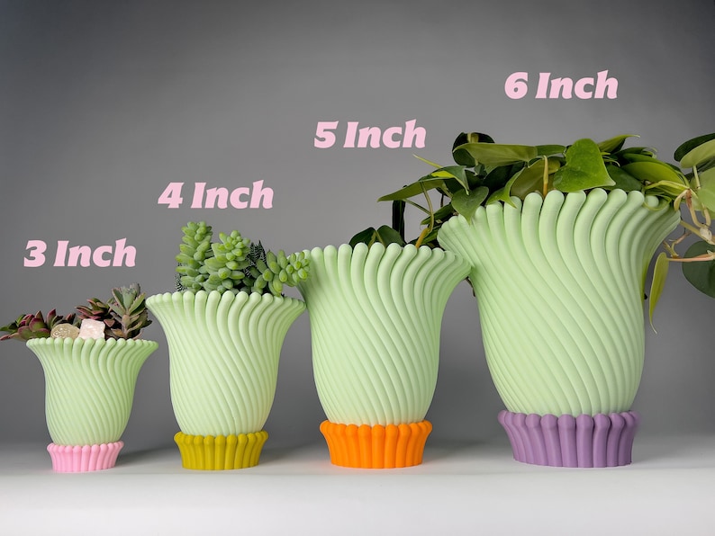 May include: Four green ceramic planters with different colored bases, ranging in size from 3 inches to 6 inches. The planters are all in the same style, with a wavy, ribbed design.