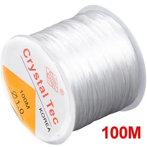 May include: A white spool of clear, elastic beading cord. The label features red text reading "Crystal Tec", with "100M" and "1.0" measurements. The spool has a white and yellow label. The text "100M" is also printed in red.