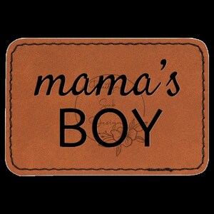 May include: A brown leather patch with a stitched border. The text "mama's BOY" is printed in black.