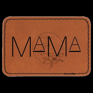 May include: A brown leather patch with the word "MAMA" in black lettering. The patch has a stitched border and a small floral design.