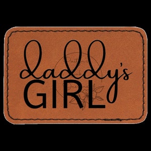 Peut inclure: Un écusson rectangulaire en cuir marron avec les mots "Daddy's GIRL" en écriture noire. L'écusson a une bordure cousue et un motif floral au centre. Le texte "Paitin's Designs Hub" est également visible.