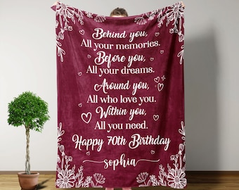 May include: A maroon fleece blanket with white floral designs and the text "Behind you, All your memories. Before you, All your dreams. Around you, All who love you. Within you, All you need. Happy 70th Birthday Sophia"