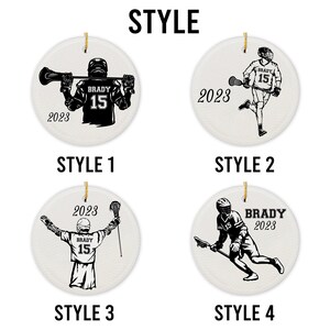 May include: Four different styles of lacrosse player ornaments. Each ornament is round and white with a black lacrosse player design. The player's jersey has the number 15 and the name "BRADY" on it. The year 2023 is also included on each ornament.