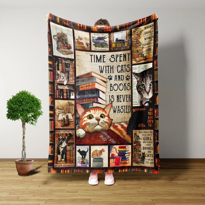 Op de afbeelding: Een bruin en beige fleece deken met een collage van afbeeldingen van katten en boeken. De deken heeft de tekst "Time Spent With Cats and Books Is Never Wasted".