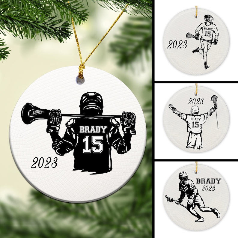 May include: White ceramic ornament with a black silhouette of a lacrosse player holding a lacrosse stick. The player is wearing a jersey with the number 15 and the name "BRADY" on the back. The ornament also includes the year "2023".