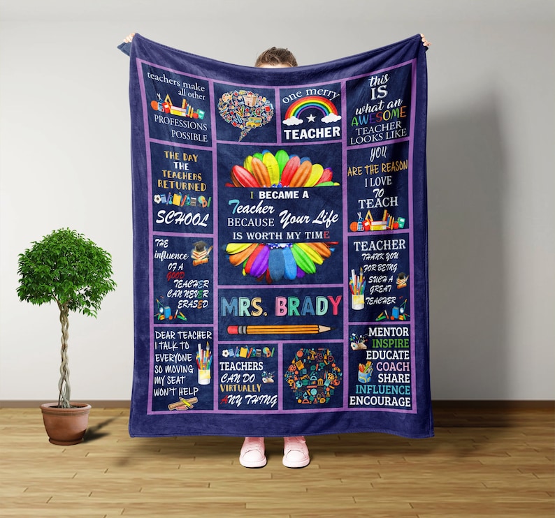May include: A purple fleece blanket with a teacher-themed design. The blanket features a rainbow, pencils, and the text "I became a teacher because your life is worth my time." and "Mrs. Brady".