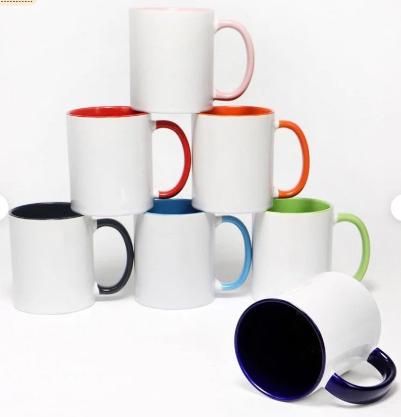 Puede incluir: Un conjunto de ocho tazas de cer&aacute;mica blanca con bordes y asas de colores. Las tazas est&aacute;n dispuestas en forma de pir&aacute;mide. La taza superior tiene un borde y un asa de color rosa, la siguiente taza tiene un borde y un asa de color naranja, la siguiente taza tiene un borde y un asa de color rojo, la siguiente taza tiene un borde y un asa de color azul, la siguiente taza tiene un borde y un asa de color verde, y la taza inferior tiene un borde y un asa de color azul.