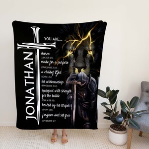 May include: Black and gold fleece blanket with a lion's face and a knight holding a sword. The blanket has the name "JONATHAN" and a religious message with bible verses.
