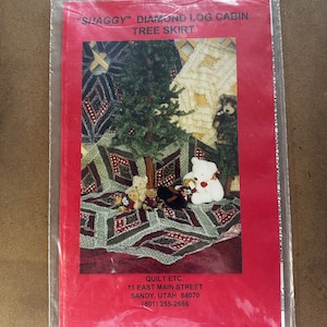 May include: A red and white printed pattern for a "Shaggy" Diamond Log Cabin Tree Skirt. The pattern features a small Christmas tree and bears. The pattern is from Quilt Etc. at 11 East Main Street, Sandy, Utah 84070. The phone number is (801) 255-2666.