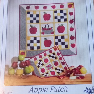 May include: A quilting pattern for an apple-themed quilt. The pattern is called "Apple Patch" and includes instructions for making a 28" x 28" quilt and a 15" x 15" quilt. The pattern is from Four Corners.