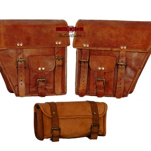May include: Set of three brown leather motorcycle saddlebags. Two large saddlebags with buckles and a smaller roll-top bag.