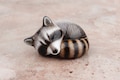 Sleeping raccoon - handmade animal figurine product logo