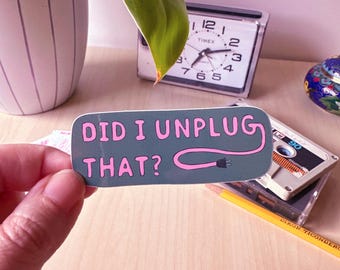 May include: A gray sticker with pink text that reads "Did I unplug that?" with a pink and gray illustration of an electrical cord.