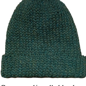 May include: A green knitted beanie hat made from a wool and acrylic blend.