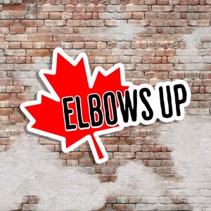 Puede incluir: Una pegatina con una hoja de arce roja con el texto "ELBOWS UP" en negro, delineado en blanco. La pegatina está sobre un fondo de pared de ladrillo.