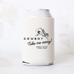 May include: White can cooler with a black and white illustration of a cowboy riding a horse. The text "COWBOY Take me away!" is printed on the cooler, along with the text "EMMA'S BACH APRIL 2025".