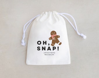 May include: White drawstring bag with a gingerbread man graphic and the text "OH, SNAP! Johnson family Recovery Kit".