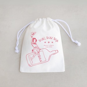 May include: A white drawstring bag with a red illustration and text. The illustration depicts a woman riding a tequila bottle. The text reads "Wild, Wild Wife" and "Ashley's Bach June 2024".
