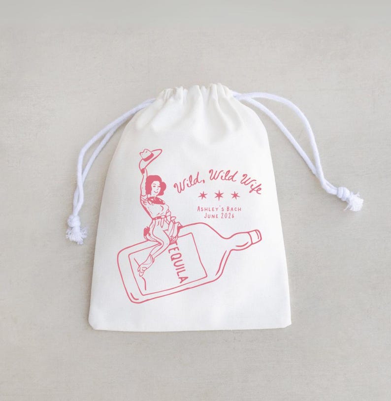 May include: A white drawstring bag with a red illustration and text. The illustration depicts a woman riding a tequila bottle. The text reads "Wild, Wild Wife" and "Ashley's Bach June 2024".