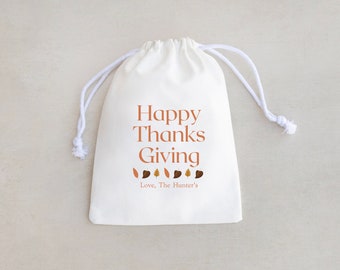May include: White drawstring bag with the text "Happy Thanks Giving" and a row of brown and orange leaves. The text "Love, The Hunter's" is below the leaves.