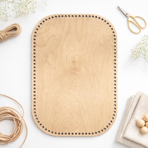 Puede incluir: Base de cesta de madera clara, de forma rectangular con esquinas redondeadas. Tiene agujeros espaciados uniformemente alrededor del perímetro para tejer. Accesorios: tijeras, cuerda y tela.