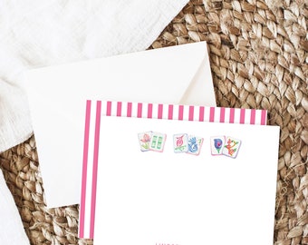 May include: Pink and white striped stationery with a white envelope. The stationery has a pink and white striped border and features four watercolor illustrations of Chinese dominoes with floral designs. The stationery is personalized with the name "Lindsey Jensen".