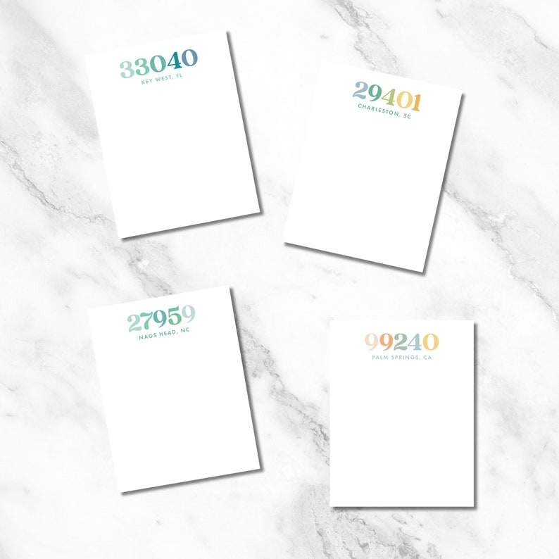 May include: Four white notepad sets with different city area codes and locations printed on them. The area codes are 33040, 29401, 27959, and 99240. The locations are Key West, FL, Charleston, SC, Nags Head, NC, and Palm Springs, CA.