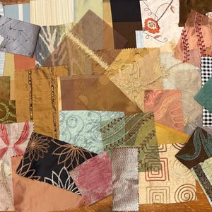 May include: A selection of fabric swatches in diverse colours and textures. The swatches feature floral, geometric, and abstract designs in shades of brown, gold, pink, green, and black. Some fabrics have beaded embellishments.