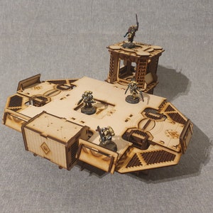 May include: A wooden model of a spaceship with four figures standing on it. The spaceship is made of multiple pieces and has a raised platform in the centre. The figures are painted in a yellow and brown colour scheme.