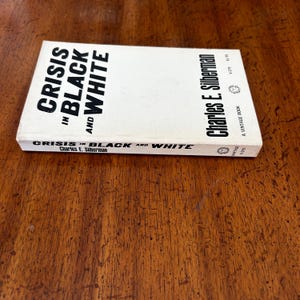 May include: A paperback book titled Crisis in Black and White by Charles E. Silberman. The cover is white with bold black text. The spine also displays the title and author name in black text against a white background, including the Vintage logo.