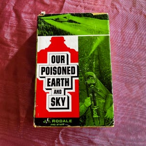 May include: Vintage book cover with the title "Our Poisoned Earth and Sky" in bold white letters on a red background. The cover features a person in a gas mask and a green landscape.